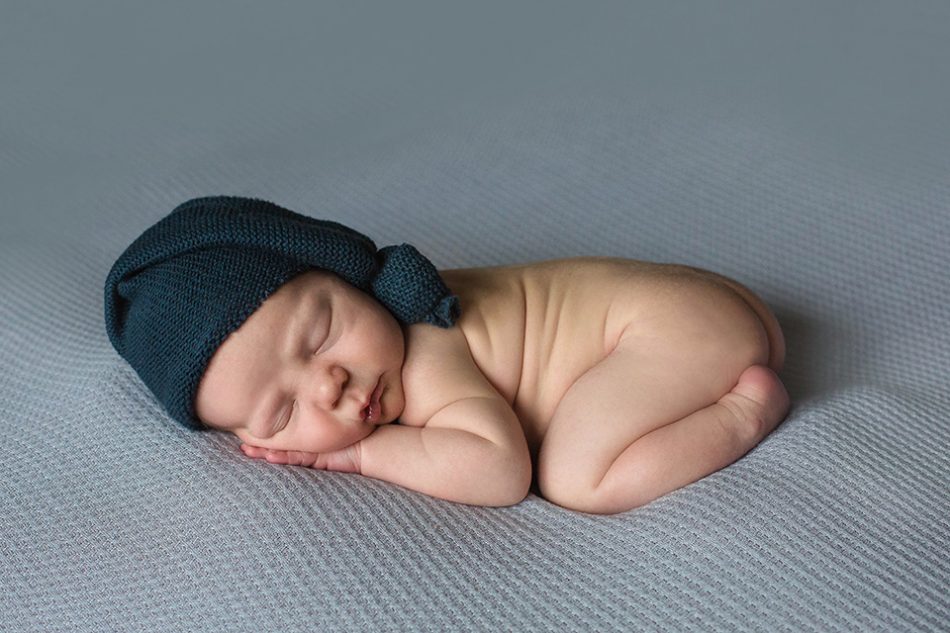 newborn on blue blanket with hat