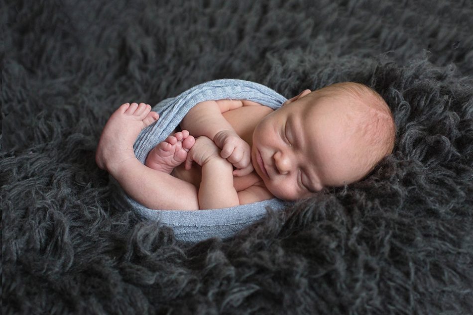baby boy wrapped in blanket newborn photographer