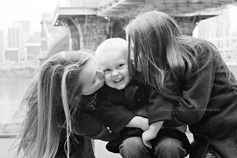 big sisters kiss their baby brother