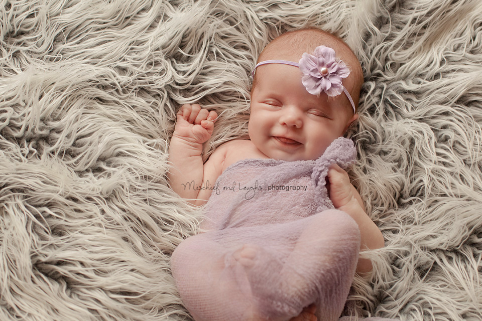 newborn baby in cincinnati smiles for the camera