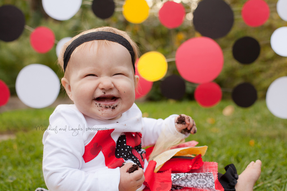 baby laughs and eats her mickey mouse birthday cake
