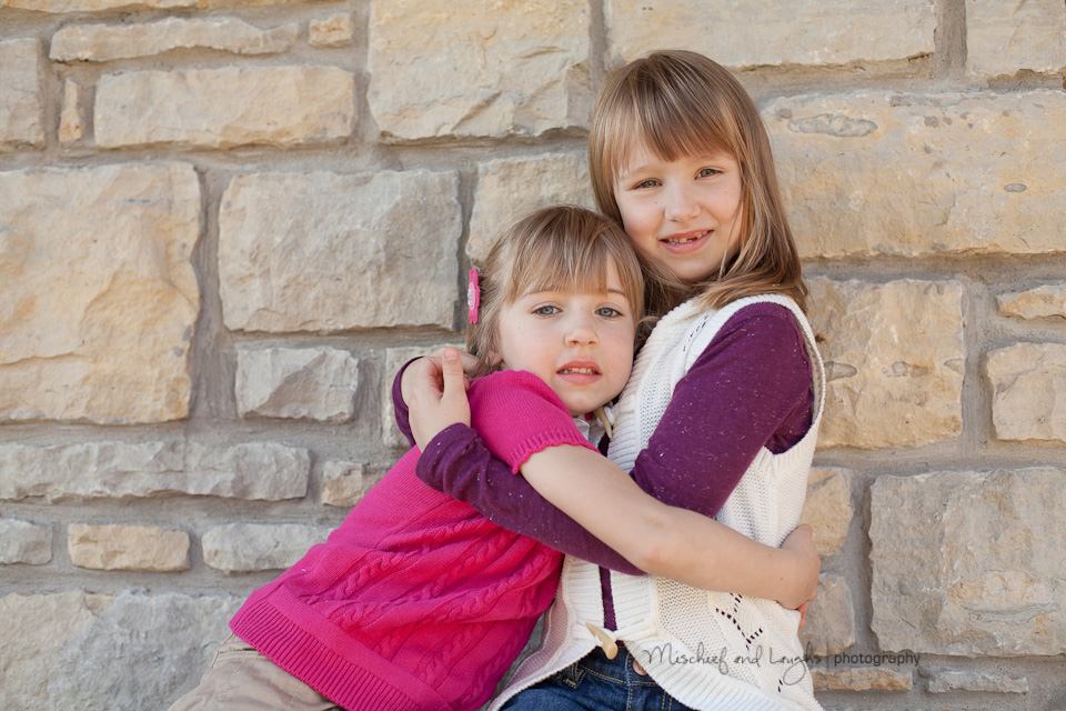 sisters hug each other during their photo session