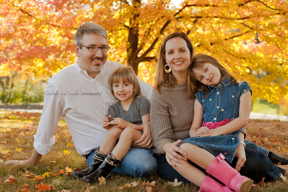 fall family portraits in the middle of the yellow leaves