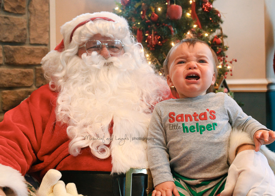 baby cries as he sits on santa's lap for pictures in northern kentucky