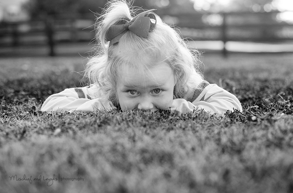 black and white portrait of a child in the grass