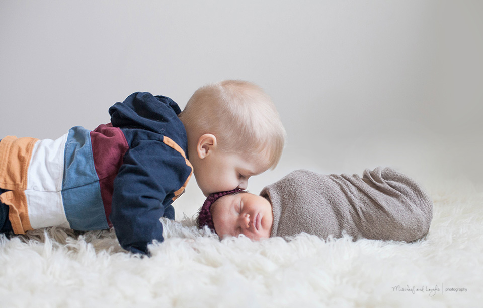 brother kissing baby