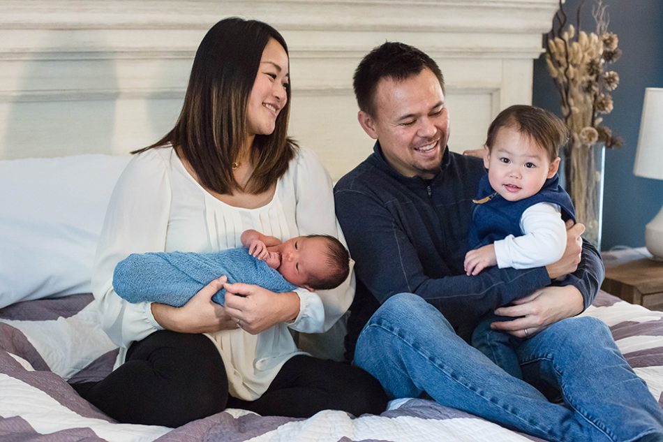 Family poses for pictures during their newborn session in their home