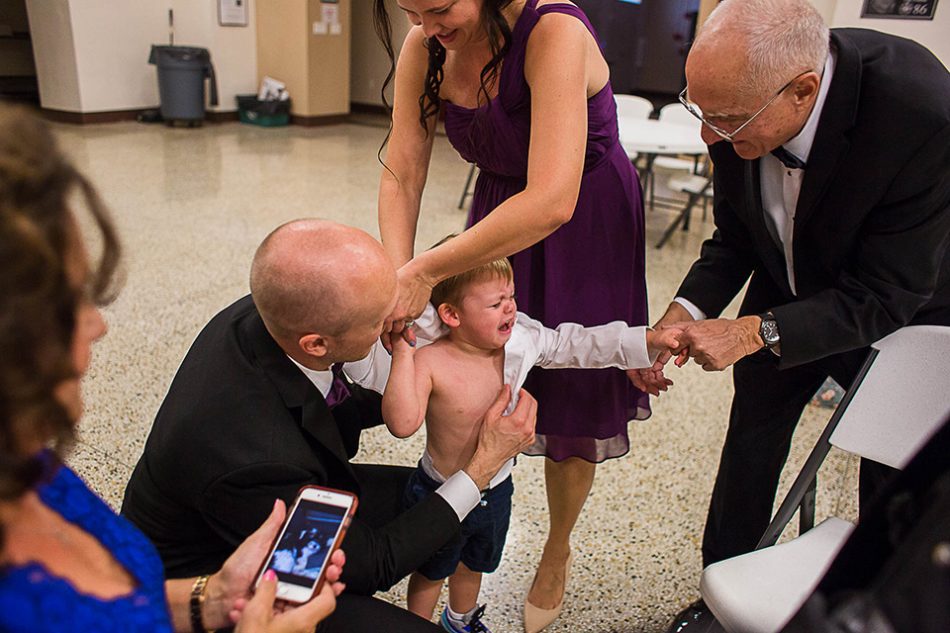Child cries as he gets dressed before a wedding