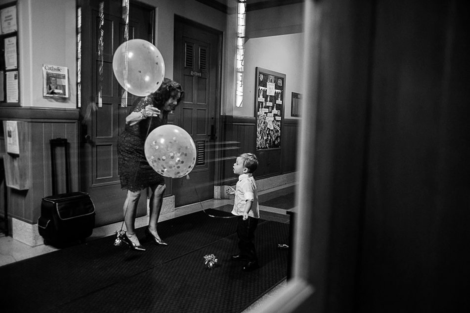child plays with balloons during a long catholic wedding mass