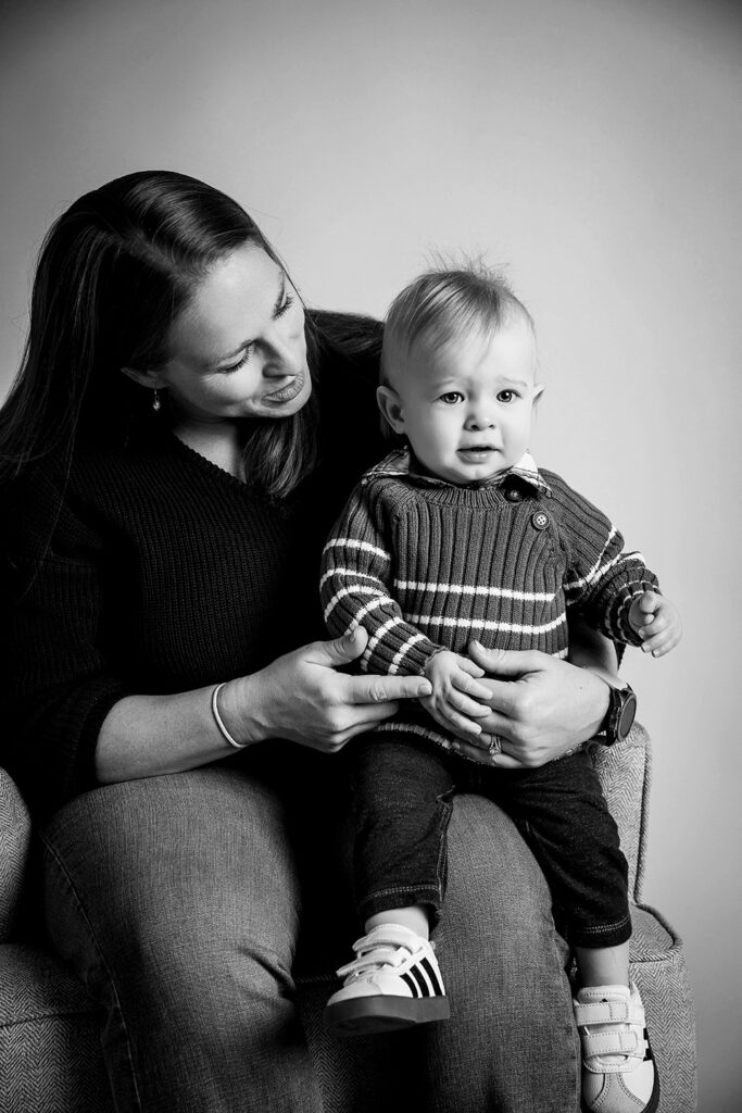 Mom holding their one-year-old son in a family portrait during his birthday photoshoot.