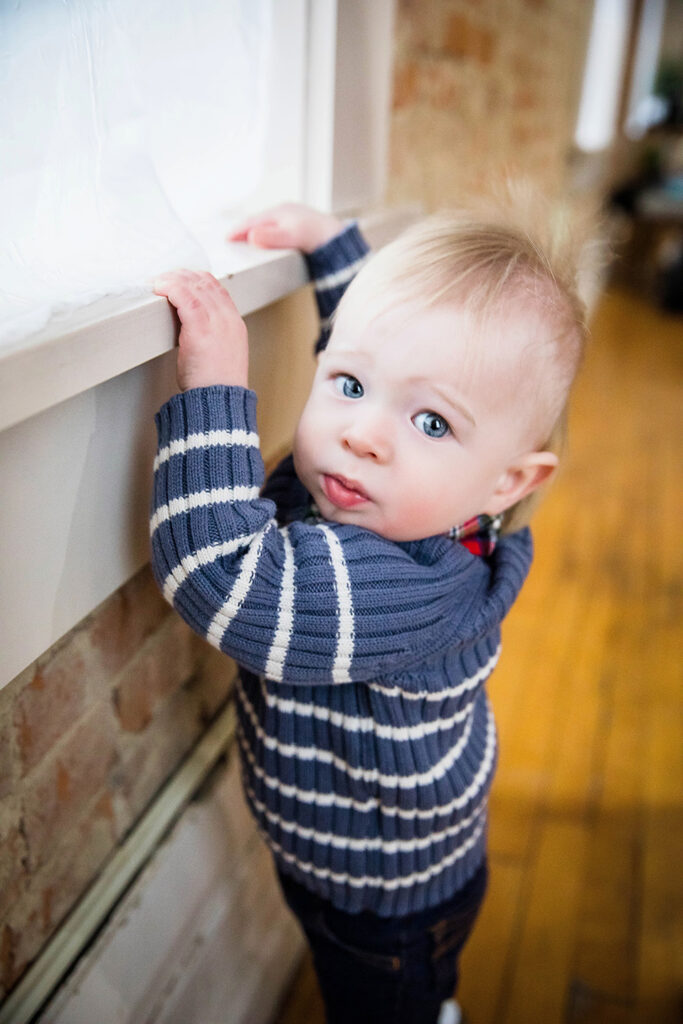 Happy one-year-old boy laughing and playing during his milestone photography session.