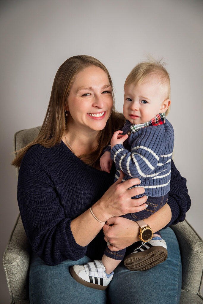 Parents hugging their baby boy during a first birthday family portrait session.