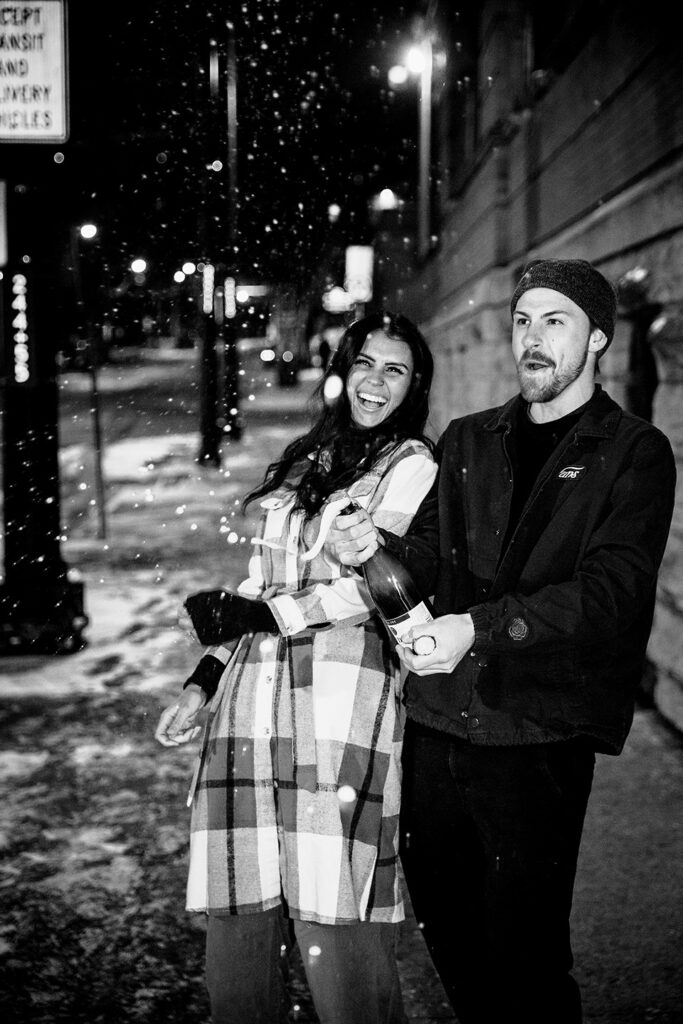 Surprise engagement party scene with the couple enjoying an outdoor champagne celebration.