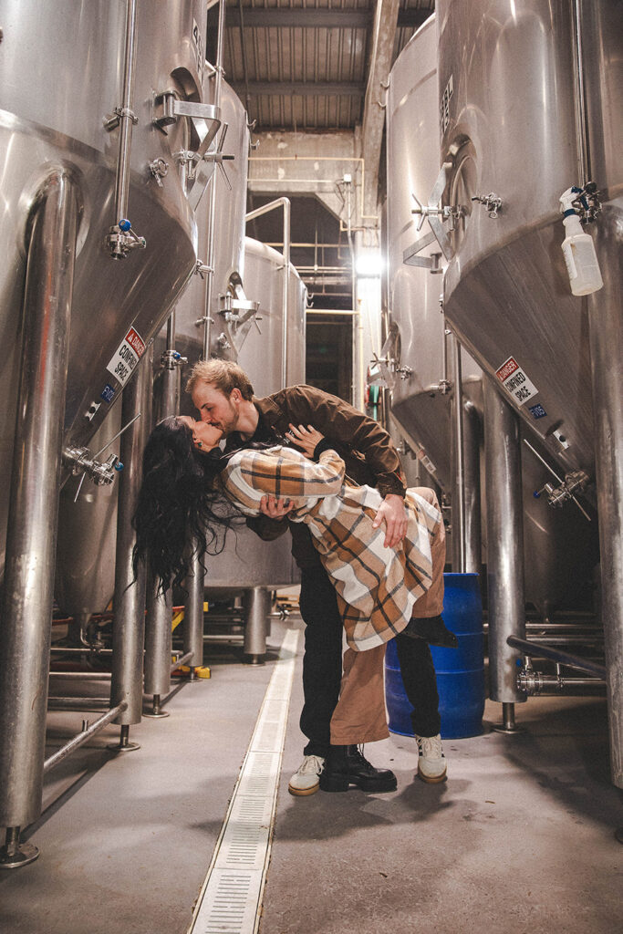 Winter engagement session with industrial brewery backdrop