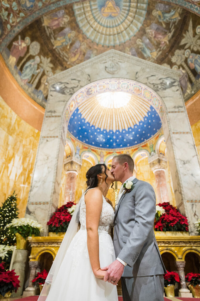 Catholic wedding first kiss in church st Willams parish cincinnati at Christmas time